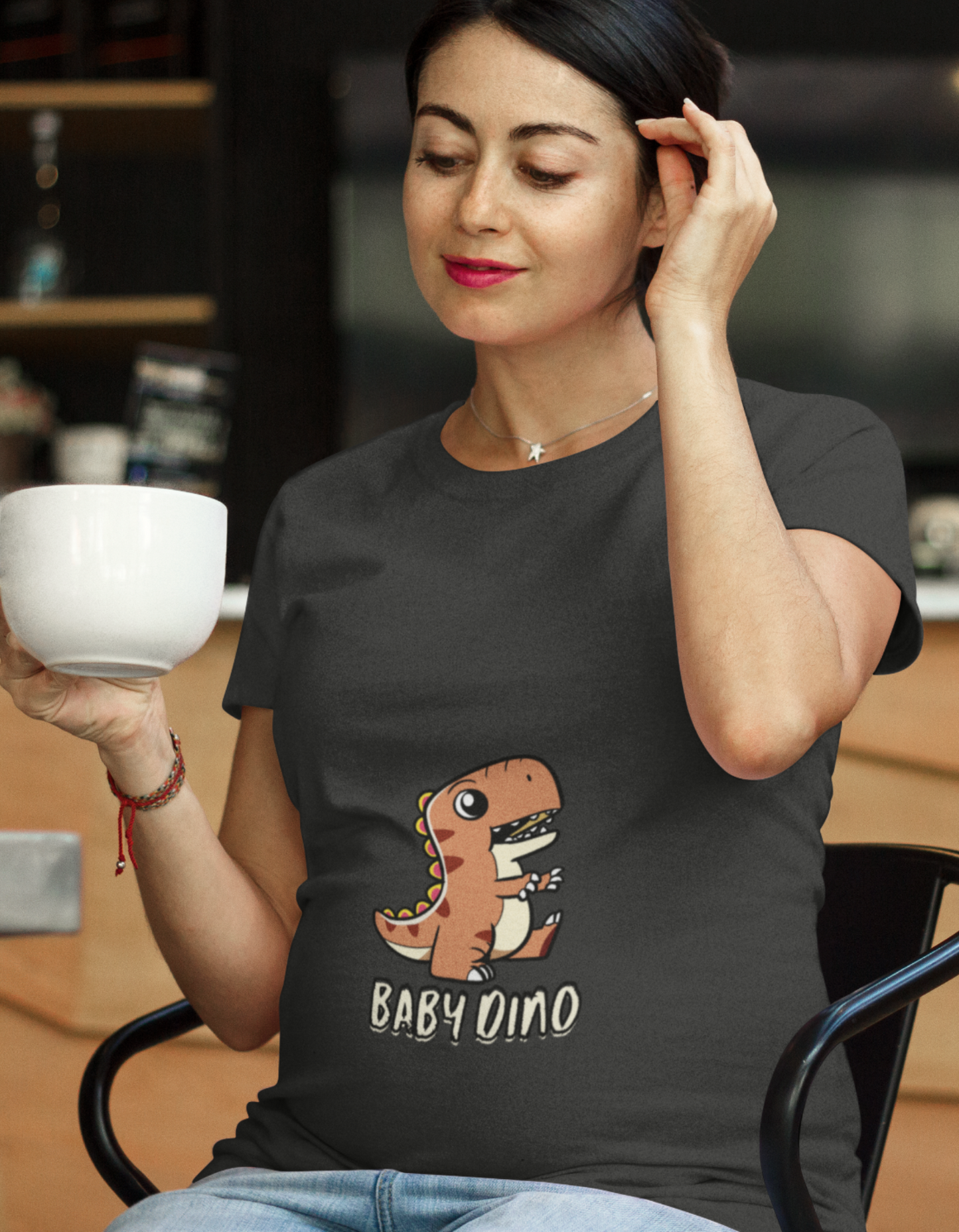 Experience comfort and style during pregnancy with our trendy Baby Dino Pregnancy T-Shirt from Womanitee. Express your individuality with our cute baby dinosaur design. Shop now for women's graphic t-shirts!