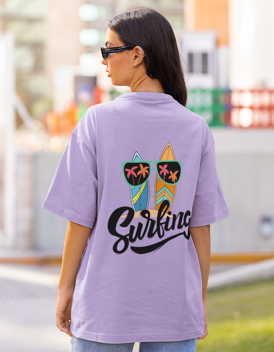 Catch the fashion wave with our Iris Lavender Oversized T-Shirt featuring surfers and sunglasses. Shop online at Womanitee for trendy women's graphic t-shirts and embrace the carefree spirit of surf culture with style and confidence.