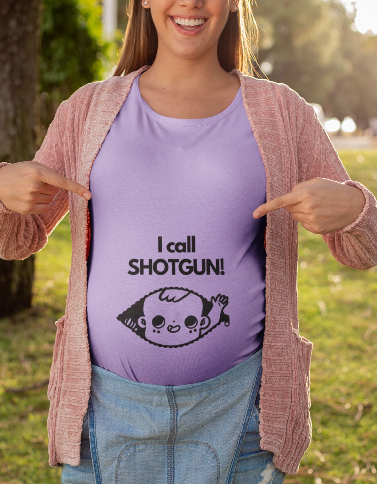 Make a bold statement with our oversized pregnancy t-shirt. Featuring an adorable baby peaking out of a zip and raising a hand, our 'I Call Shotgun' t-shirt lets you showcase your unique motherhood journey. Shop now and embrace comfort and style at Womanitee!