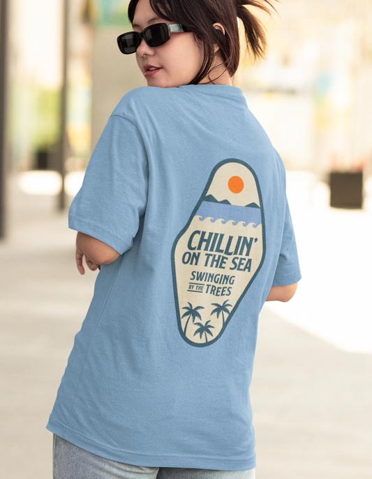 Embrace casual cool with our Baby Blue Swingin' and Chillin' Oversized T-Shirt. Experience carefree coastal vibes and elevate your style effortlessly. Shop online at Womanitee for trendy women's graphic t-shirts.