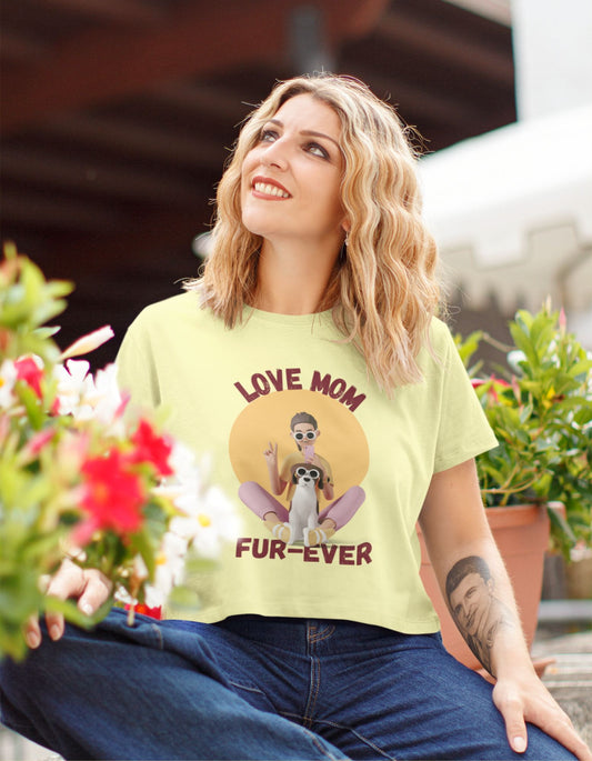 Discover the perfect blend of style and love with our Women's 'Love Mom Fur-ever' Crop Top. This butter yellow crop top, adorned with an illustration of a woman and her dog, lets you showcase your special bond with your fur baby. Order now and embrace pet mom fashion!